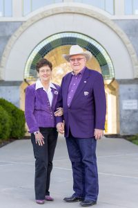 Dan and Beth Bird wearing their K-State purple standing in front of the tiled archway at the Beach Museum of Art on the Kansas State University campus.