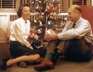 Mary and Morgan Jarvis sitting together beside the Christmas tree in 1955.