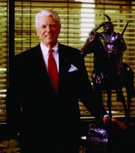 R. Crosby Kemper Jr. standing next to a bronze replica of "The Scout" by Cyrus E. Dalin, 1915. The artwork depicts a Sioux Indian on horseback.