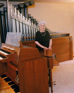 Marion Pelton standing in front of the pipe organ in her home. She preferred to have the pipe organ in the living room rather than a sofa or chair.
