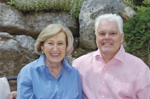 Eleanor and Bill Stolzer smiling and sitting side by side in front of a rock wall.