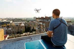 Drone operator flying over rooftops