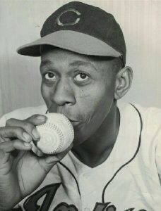 Black and white photograph of Satchel Paige kissing a baseball