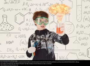 Visual of a young man holding a beaker and observing a chemical reaction to demonstrate action centered learning.