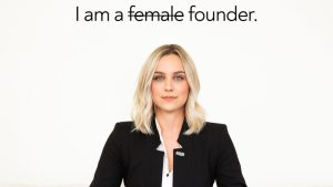 A white woman with blonde hair in the middle of the frame, staring directly at the camera. She's wearing a white shirt and black business suit jacket. Above her are the words "I am a female founder," but with the word "female" crossed out.