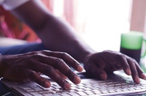 A close-up of a person typing on a computer